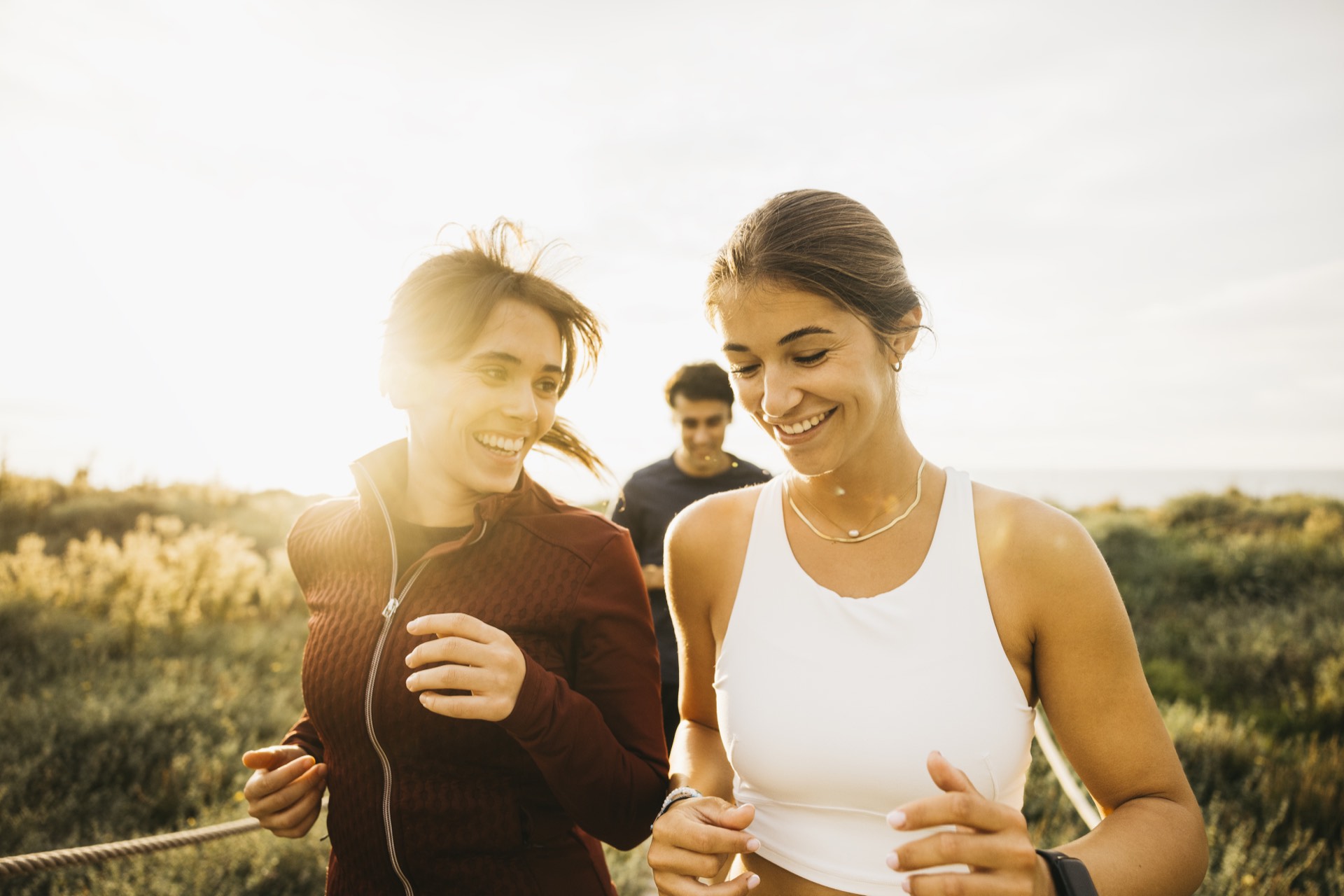 Two women jogging and laughing in the evening light