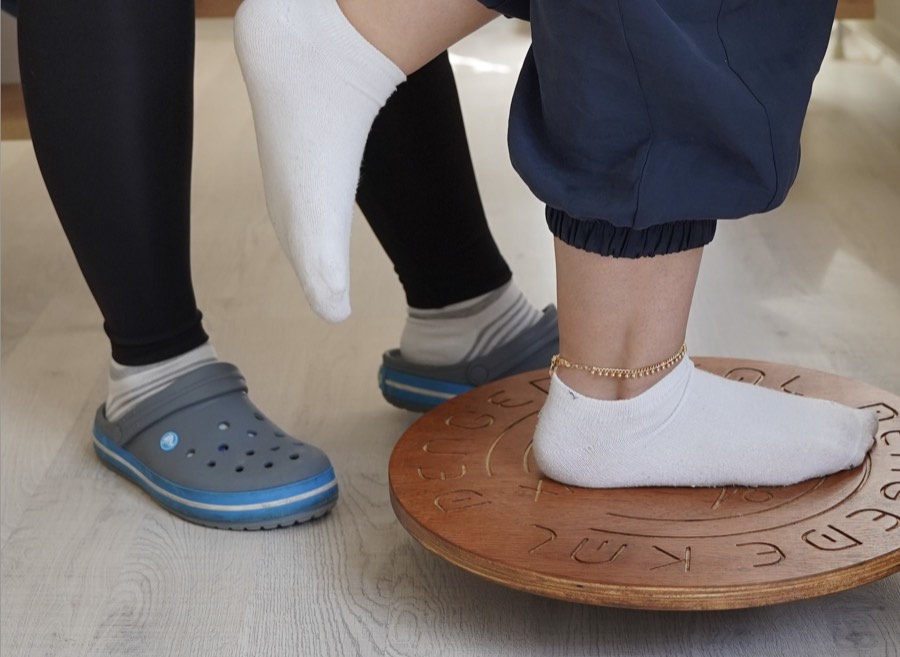 Patient balancing on a wobble board during rehab