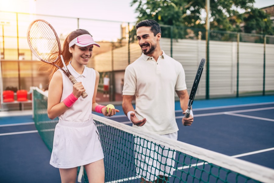 Two tennis players talking at the net