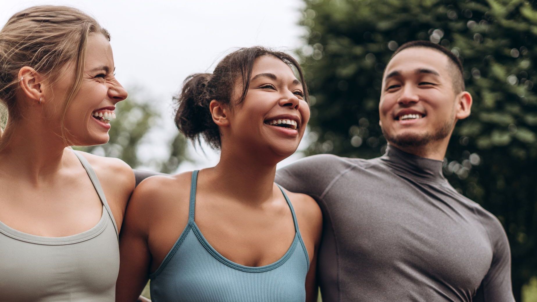 Three friends laughing together after exercise