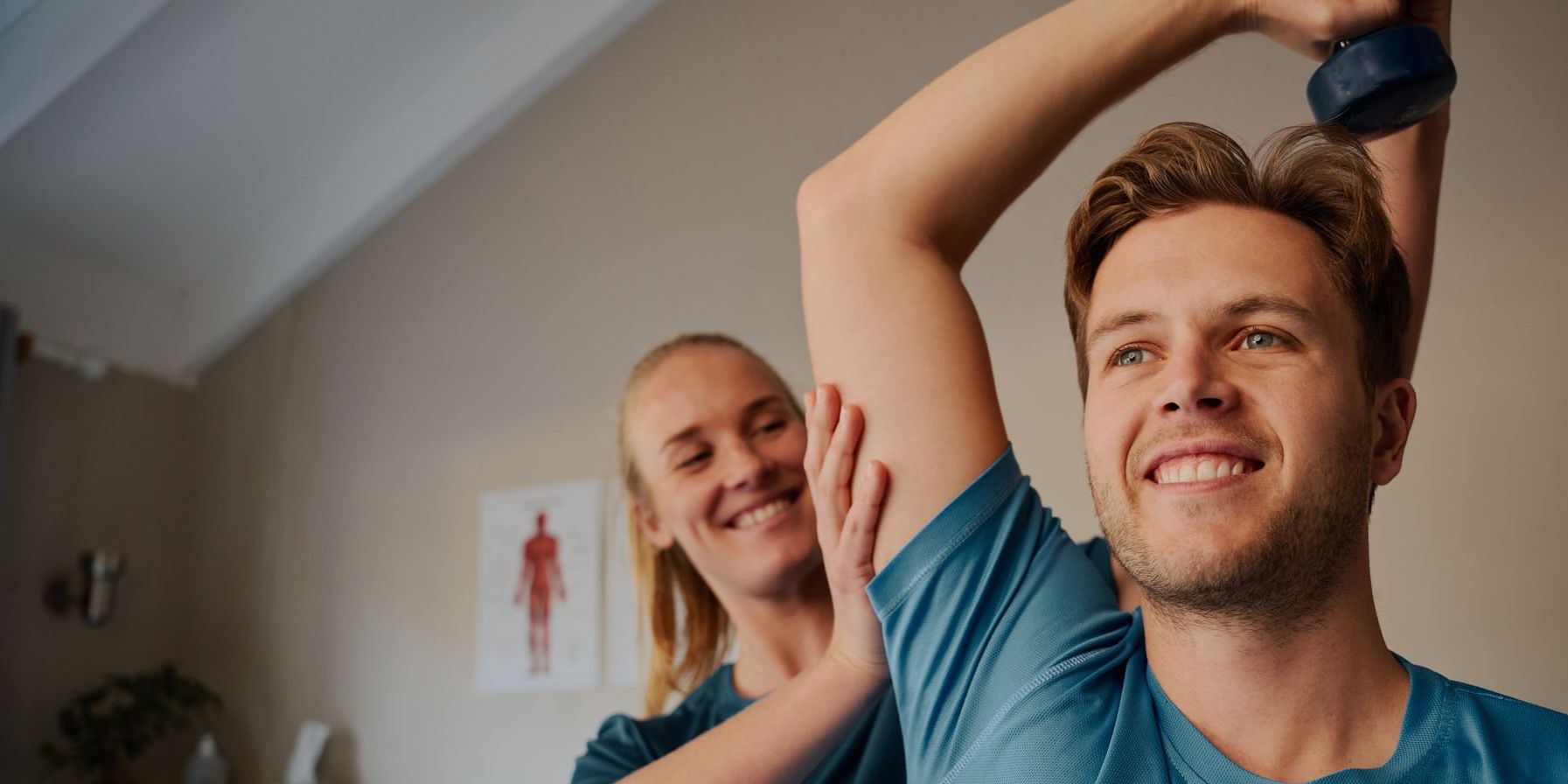 Physiotherapist guiding a patient through an overhead dumbbell exercise